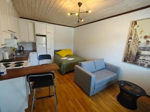 a small room with a bed and a chair and a kitchen at As 8 Viima inc Sauna in Valkeakoski