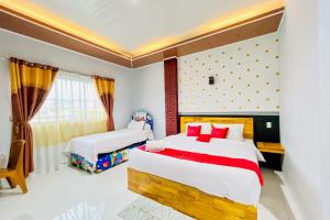 a bedroom with two beds and a window at RedDoorz at Hotel Dieng Berastagi in Berastagi +21 photos
