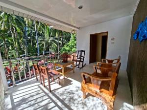 a room with chairs and a balcony with a view at Jenalfe Guest House in Camiguin