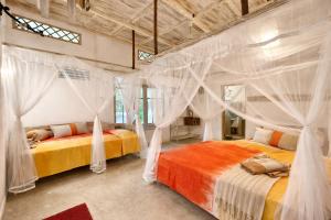 two beds in a bedroom with drapes at Deep Blue in Matara +181 photos