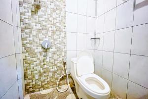 a bathroom with a toilet and a shower at RedDoorz at Hotel Dieng Berastagi in Berastagi