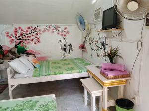 a room with a bed and a table and a desk at Cronin Residences in Oslob