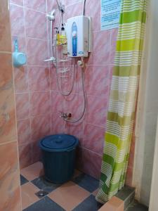 a shower with a blue bucket in a bathroom at Cronin Residences in Oslob +48 photos
