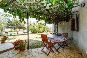 a table and chairs under an umbrella on a patio at Medulin Apartment 12 in Medulin