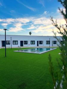 a building with a swimming pool in a field of grass at Atrio Homes Sansueña in Córdoba