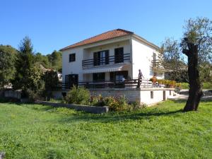 a house with a person standing in front of it at Apartment Pasman 1 in Pašman