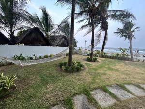a hammock on a beach with palm trees and the ocean at Waves - for Family & Married Couples only in Mahabalipuram