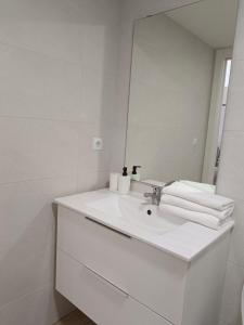 a white bathroom with a sink and a mirror at RockSide Residences Suites La Línea VII in La Línea de la Concepción