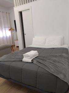 a bedroom with a bed with two towels on it at RockSide Residences Suites La Línea VII in La Línea de la Concepción
