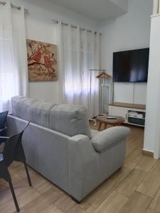 a living room with a couch and a flat screen tv at RockSide Residences Suites La Línea VII in La Línea de la Concepción