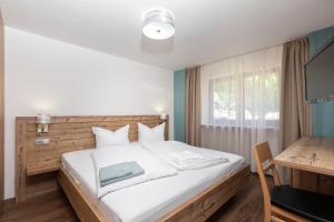 a bedroom with a bed with a desk and a window at Garni Stefani in Vent
