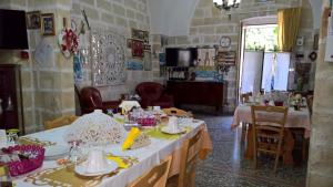 un comedor con 2 mesas y sillas y una habitación con en Grekal Bed Salento, en Porto Cesareo