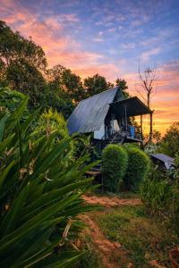 a small house with a tin roof in a field at Angels Nest Home stay plantation Mountain area balconey SunRice view Nearby Ngarhole wild life , Tholpetty wild life , Pakshipathalam Bird santuary , Kuruva island # Thirunelly & Thrissilery Temple Near by Secure Stay Wayanad Kerala in Chegāt +43 photos