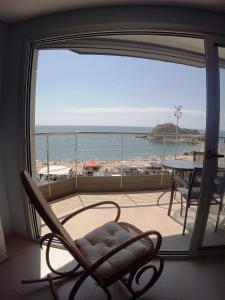 balcón con silla y vistas a la playa en Aiguaneu Sa Palomera, en Blanes