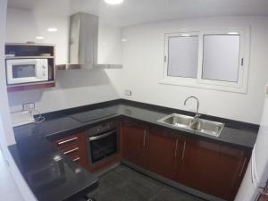 a kitchen with a sink and a microwave at Aiguaneu Sa Palomera in Blanes