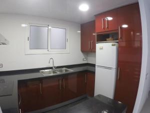 ブラナスにあるAiguaneu Sa Palomeraのキッチン(木製キャビネット、白い冷蔵庫付)
