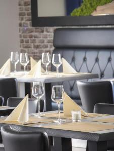 a row of tables with wine glasses and napkins at Fairschlafen Boutique Hotel in Neustadt in Holstein