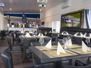 a restaurant with tables and chairs and a bar at Fairschlafen Boutique Hotel in Neustadt in Holstein