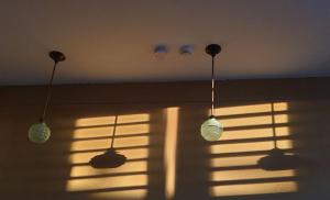 three light bulbs hanging from a window with blinds at Bed & Breakfast Exterlaer in Antwerp