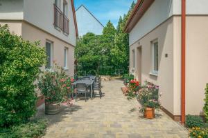a patio with a table and chairs and flowers at Rév-Panzió in Abádszalók