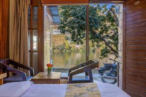 a bedroom with a view of a lake from a window at By the Lakeside in Bhīm Tāl