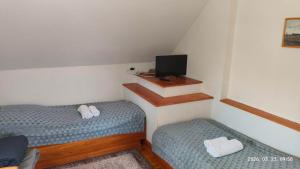 a small room with two beds and a television at Rév-Panzió in Abádszalók
