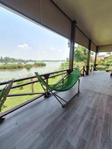 a hammock on a porch with a view of the river at Champa resort in Don Det