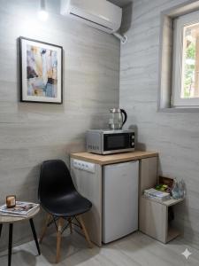 a kitchen with a microwave and a chair at Studio MD in Chişinău