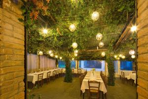 a dining room with tables and chairs and plants at La Casa Di Campagna in Magione