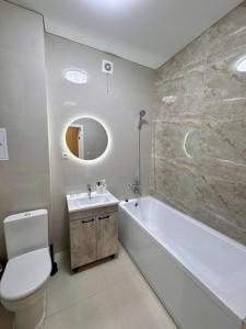 a bathroom with a tub and a toilet and a sink at A-Six Apartment, ЖК Достар 26 in Karagandy