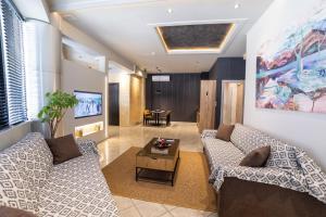 a living room with two couches and a table at Omega Suites 30 in Tríkala