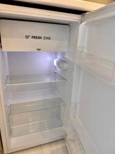 an empty refrigerator with its door open with its door at A-Six Apartment, ЖК Достар 26 in Karagandy