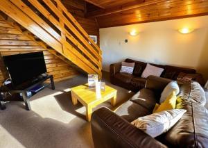 a living room with a couch and a tv at Tor View Lodge with Hot Tub & Sauna - Spa Resort - South Devon in Chudleigh +56 photos