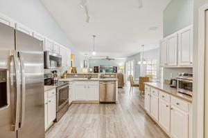 a kitchen with white cabinets and stainless steel appliances at 601 Benedictine Ter in Sebastian