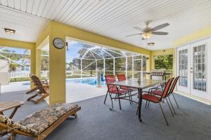 a dining room with a table and chairs and a pool at 601 Benedictine Ter in Sebastian