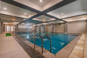 a large swimming pool in a building at Treebo Aashirwad Bliss Inn With Swimming Pool in Jaipur