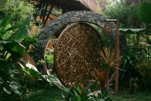 a large wheel in a garden with a stone bridge at Bamboo Hill in Lương Sơn