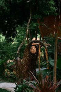 a wicker chair in a garden with a chandelier at Bamboo Hill in Lương Sơn