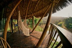 a hammock hanging from a straw roof at Bamboo Hill in Lương Sơn