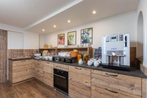 a large kitchen with wooden cabinets and a coffee maker at Garni Stefani in Vent