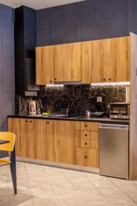 a kitchen with wooden cabinets and a stove at Omega Suites 30 in Tríkala +40 photos