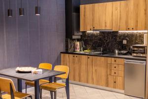 a kitchen with a table and chairs and a table and a counter at Omega Suites 30 in Tríkala