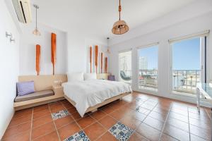 a bedroom with a bed and a couch and windows at Mare Cielo in Xiaoliuqiu