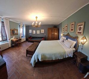 a bedroom with a large bed and a couch at B&B Podere Merlo in Parma