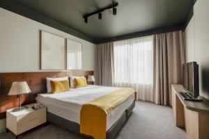 a hotel room with a bed and a television at Adina Apartment Hotel Budapest in Budapest