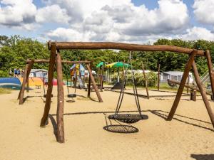 a playground with a swing set in the sand at DCU-Camping Hesselhus in Silkeborg