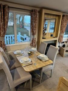 a dining room table with chairs and a table and a window at Tattershall Lakes 49 Larch View in Tattershall