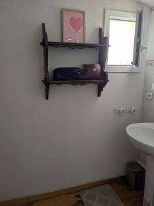 a bathroom with a sink and a shelf on the wall at Maison 5 chambres front de mer classée 3 étoiles tourisme in Narbonne +17 photos