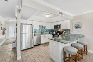 a kitchen with white cabinets and a stainless steel refrigerator at 1045 Wave Crest Avenue in Indialantic
