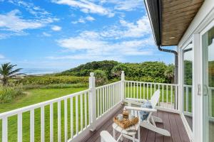 a porch with two chairs and a table and a view of the ocean at 1045 Wave Crest Avenue in Indialantic